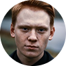 Person with red hair and serious expression, emphasizing the importance of passport services for clients seeking fast and secure processing.